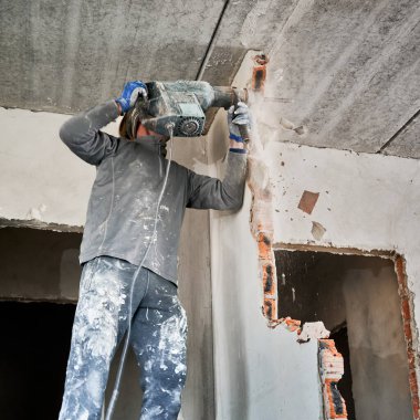 Çarpışma modunda delgi ile duvarın parçalanması. Bitişik duvarları yıkıp yaşam alanını genişletmek için elden geçirme.