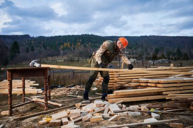 Ahşap çerçeve inşa eden bir işçi. Marangoz tahta kalasları ölçmek ve kurşun kalemle iz bırakmak için mezura kullanıyor. Marangozluk kavramı.