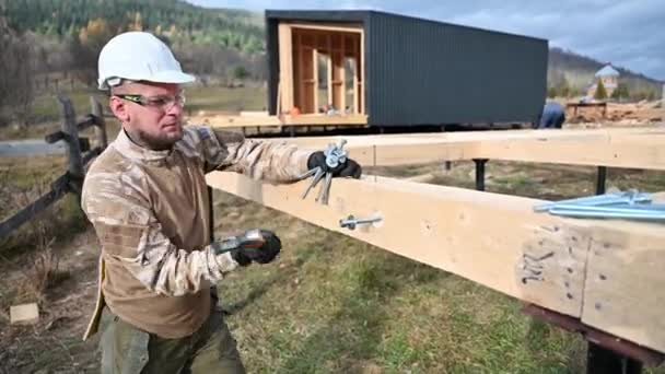 工人在桩基础上建造木制框架房屋 木匠用锤子把螺栓锤打成木板 木匠概念 — 图库视频影像