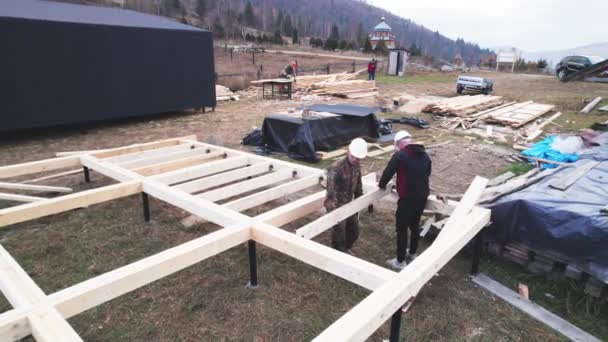 Arbeiter Bauen Holzrahmenhäuser Auf Pfahlfundamenten Zimmerleute Die Mit Hämmern Holzbalken — Stockvideo