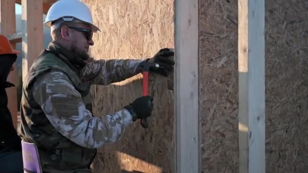 Stolarze Wbijający Gwóźdź Panel Osb Ścianie Przyszłego Domku Mężczyźni Budują — Wideo stockowe