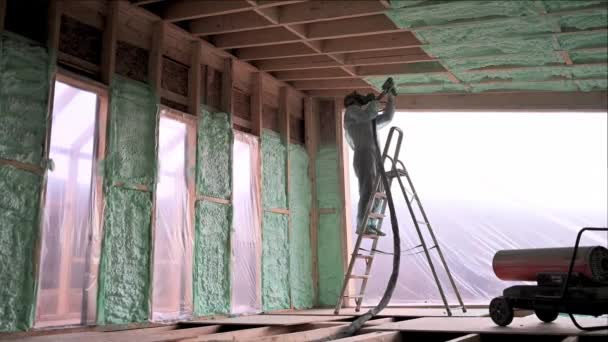 Male Builder Insulating Wooden Frame House Man Worker Spraying Polyurethane — Stock videók