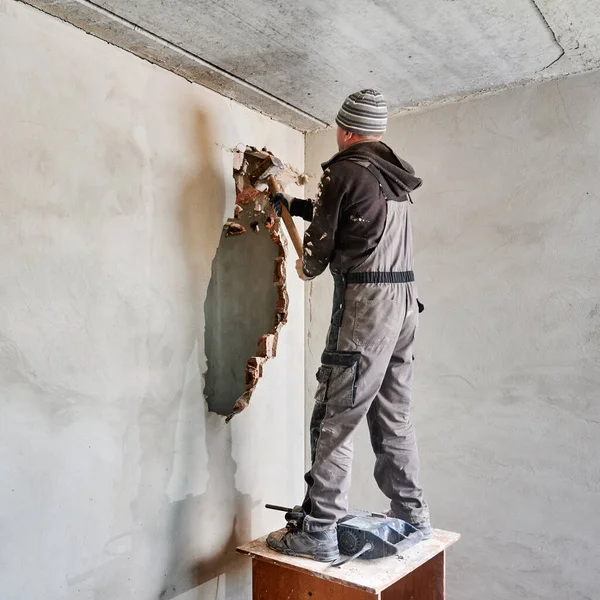 Full Length Man Builder Standing Wooden Table Breaking Wall Hammer — Stockfoto