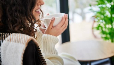 Kıvırcık genç kadın, çağdaş ahır evinde hafta sonlarının tadını çıkarıyor. Mutlu bayan turistlerin yeni kulübesinde çay içmelerini kapatın..