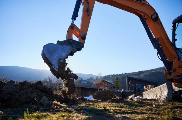 Excavator excavate earth at construction site in the evening.