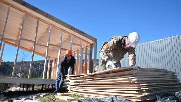 木匠用圆锯切割木制Osb板 工人在桩基础上建造木制框架房屋 木匠概念 — 图库视频影像