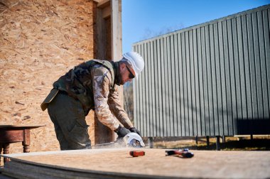 Marangoz tahta işletim tahtası kesmek için testere kullanıyor. Ahşap çerçeve inşa eden bir işçi. Marangozluk kavramı.