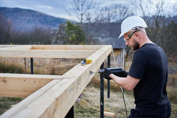 Man Building Wooden Frame House Pile Foundation Male Worker Drilling — Foto Stock