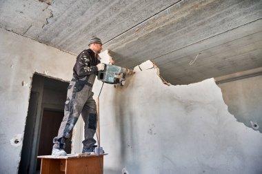 Yıkıcı çekici olan işçilerin duvarları yıkması. Evde genel onarım büyük bir oturma odası yaratmak için iki odayı ayıran duvarların yıkılması ile yapıldı..