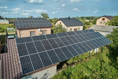 Aerial top view of new modern house cottage with solar photovoltaic panel system on house roof