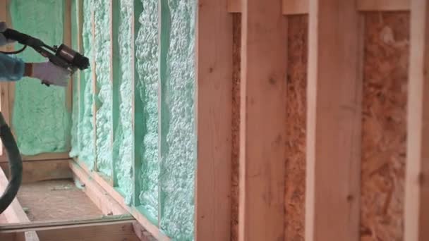Male Builder Insulating Wooden Frame House Man Worker Spraying Polyurethane — Stock video
