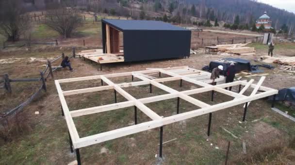 斯堪的那维亚风格的棚屋的木制框架结构空中景观 山地正在施工的桩基础上 — 图库视频影像