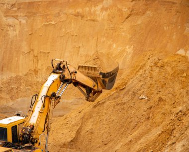Büyük sarı hidrolik endüstriyel kazıcı, demir kovası madencileri, büyük kumlu bir kariyerin içinde kum kazma ve yükleme,. 