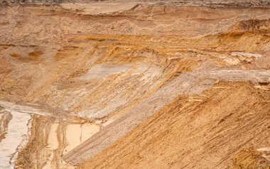 Doku kumu, kabartma yüzeyi, çok renkli katmanlar ve granül büyüklüğünde farklılık, açık hava kum kariyerinde, maden cevheri ve inşaat için kum çıkardıktan sonra. 