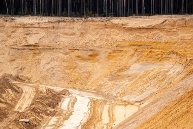 Doku kumu, kabartma yüzeyi, çok renkli katmanlar ve granül büyüklüğünde farklılık, açık hava kum kariyerinde, maden cevheri ve inşaat için kum çıkardıktan sonra. 