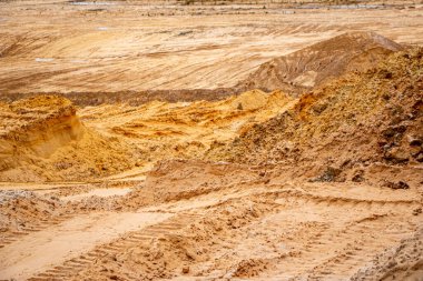 Doku kumu, kabartma yüzeyi, çok renkli katmanlar ve granül büyüklüğünde farklılık, açık hava kum kariyerinde, maden cevheri ve inşaat için kum çıkardıktan sonra. 