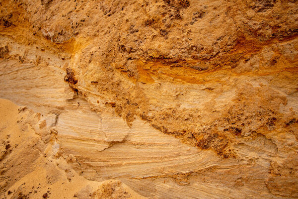 Текстурный песок с рельефной поверхностью, разноцветные слои и разного размера гранул, в карьере наружного песка, после добычи руды и песка для строительства. 