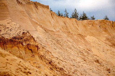 Doku kumu, kabartma yüzeyi, çok renkli katmanlar ve granül büyüklüğünde farklılık, açık hava kum kariyerinde, maden cevheri ve inşaat için kum çıkardıktan sonra. 