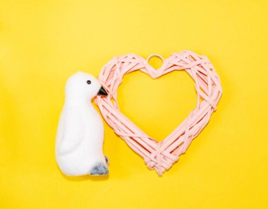 Güzel pembe hasır kalp, doğal asma dallarından, şenlikli aksesuarlarla, cam oyuncaklarla ve süslemelerle, Sevgililer Günü veya Kadınlar Günü konsepti için, aşk itirafları