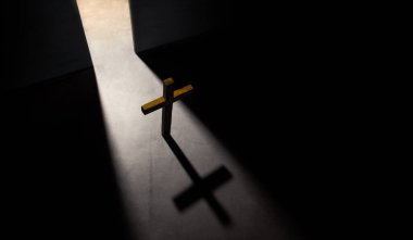 Spirituality, Hopefulness and Religion Concept. Wooden Christian Cross. Light Shading from the Opening Door. Symbol of Humility, Supplication,Believe and Faith for Christian People