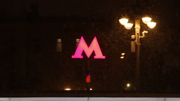 モスクワ ロシア 12月23 2019 モスクワ地下鉄のロゴ 大雪の下 街路灯の近くに赤い明るい文字M 雪の結晶が飛び交う — ストック動画