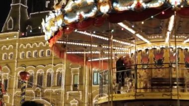 MOSCOW, RUSSIA - 23 Aralık 2019: Moskova 'daki Kızıl Meydan' da oyuncak atlarla dolu büyük bir atlıkarınca. Noel pazarında insanlar tatillerde birlikte eğleniyor. Mutlu çocuklu kadın.