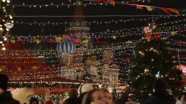 MOSCOW, RUSSIA - 23 Aralık 2019: Moskova 'nın Kızıl Meydan kentindeki Noel pazarındaki insanlar, Moskova' da yeni yıl için Kızıl Meydan 'ı süsleyip aydınlattılar. Arka planda Basil Katedrali