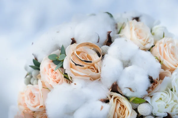 Anéis de casamento em um buquê de rosas e algodão — Fotografia de Stock