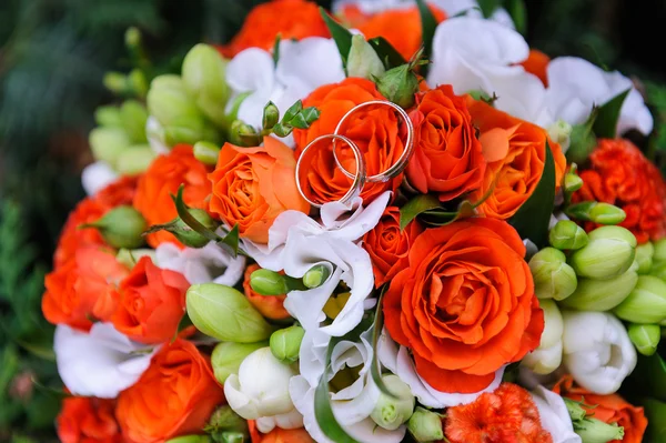 Anéis de casamento em um buquê de rosas — Fotografia de Stock