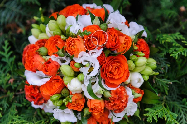 Anéis de casamento em um buquê de rosas — Fotografia de Stock