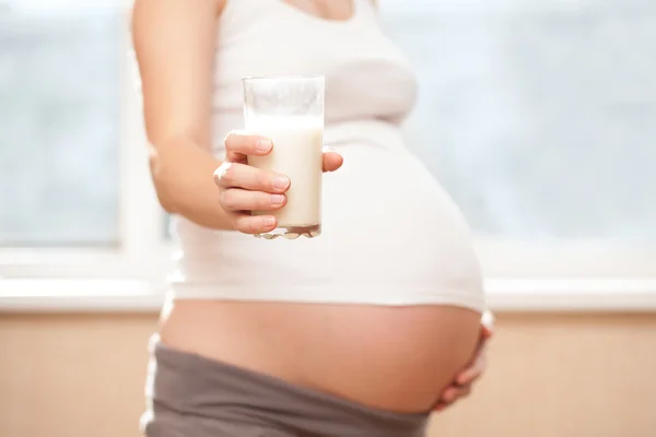 Pregnant girl and milk glass — Stock Photo, Image