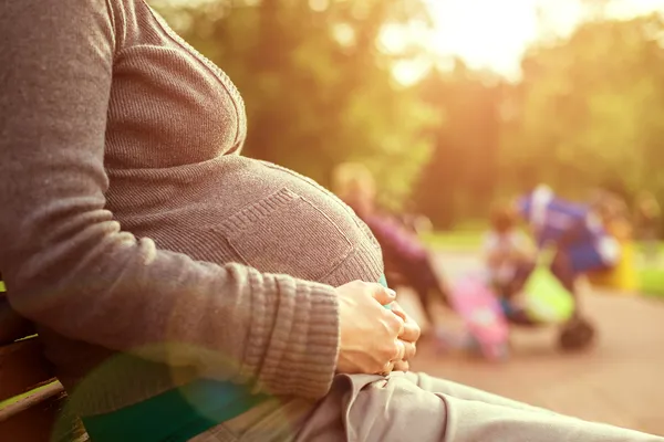 Gravid kvinna sitter på en bänk — Stockfoto