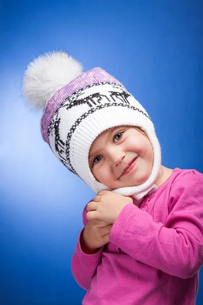 Retrato de una adorable niña con un sombrero de invierno rosa y blanco de punto . —  Fotos de Stock