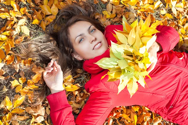 Молодая женщина с осенними листьями и осенью желтый кленовый сад фон — стоковое фото