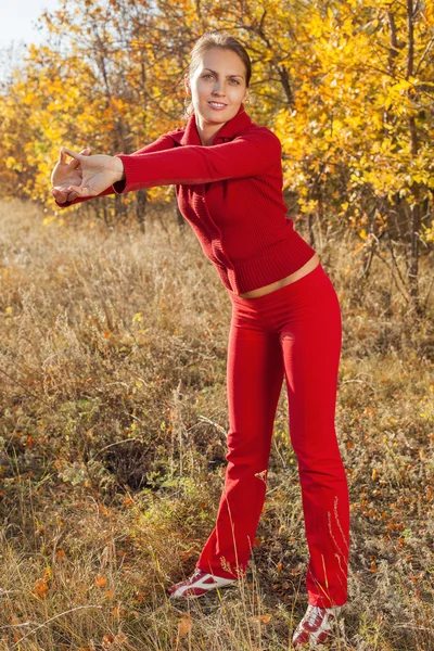 Young woman stretching before her run outdoors on a cold fall, winter day — Stock Photo, Image