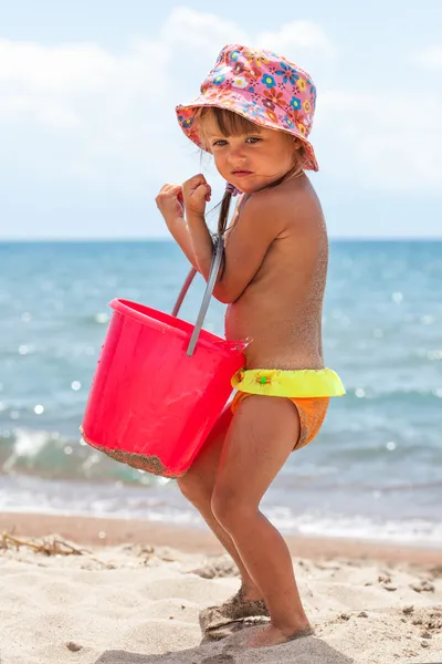 Vertical photo of toddler girl playing with toys at beach — Stock Photo, Image