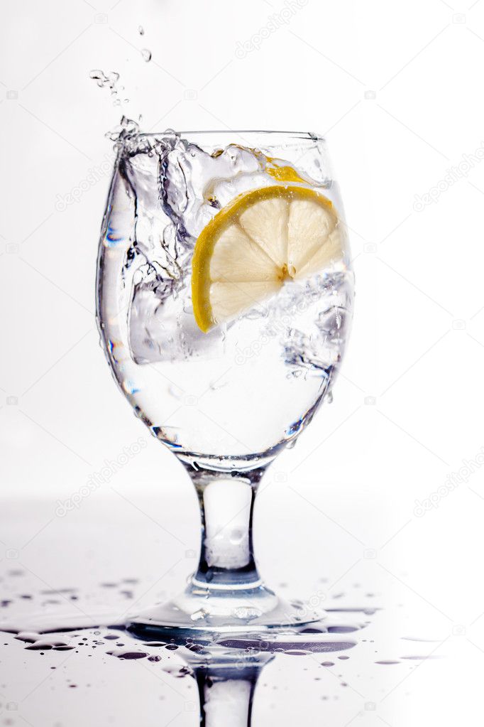 Drink with ice and lemon slice close-up isolated on white