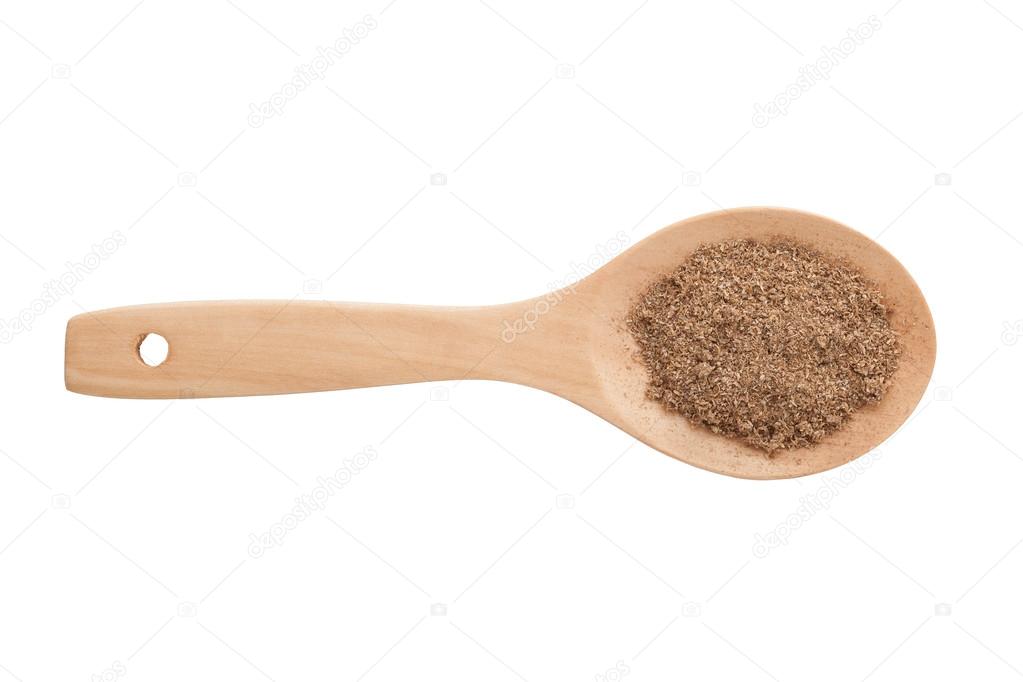 Ground nutmeg and wooden spoon isolated on white background