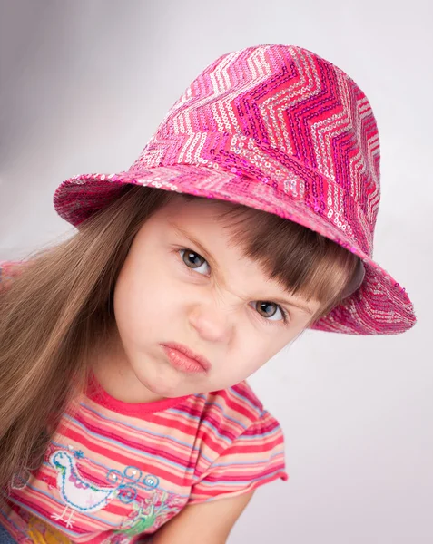 Portrait of an angry baby girl in hat. — Stock Photo, Image