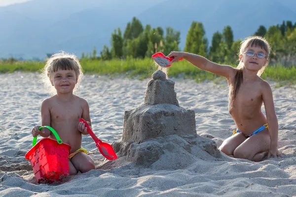 Two girls building sandcastle — Stock Photo, Image