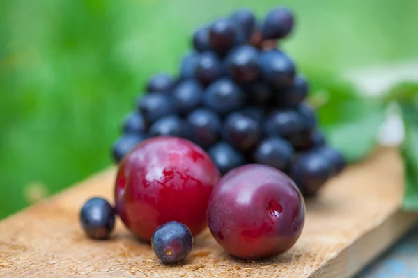 Ciruelas y uvas a bordo — Foto de Stock