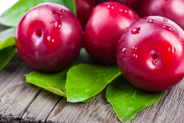 Fresh plums with green leaves — Stok fotoğraf