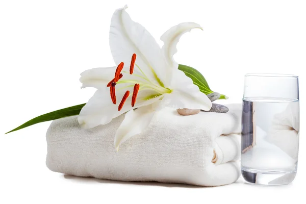 Lily on towel with glass of water — Stock Photo, Image