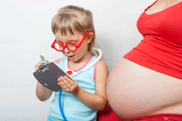 Kleine dochter met zwangere moeder — Stockfoto