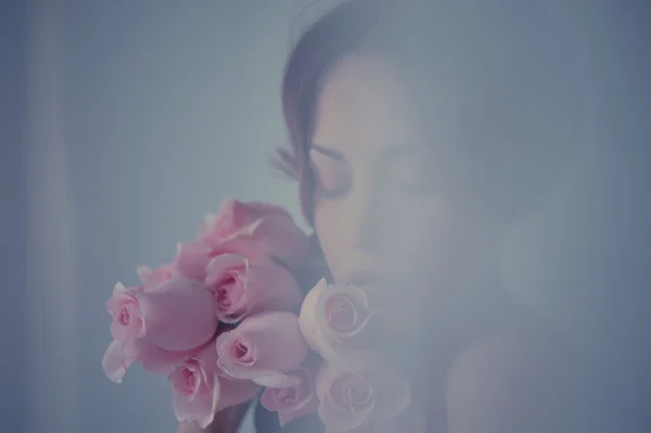 Viehättävä nainen ruusuilla — kuvapankkivalokuva