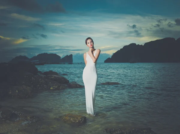 Senhora de vestido branco em uma praia — Fotografia de Stock