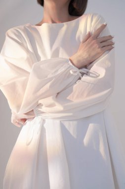 Güneş ışığı altında beyaz elbiseli dalgın esmer 