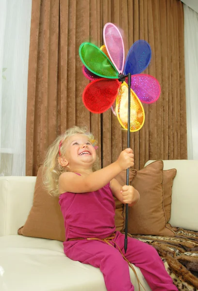 Babymeisje met pinwheel zitten in Bank — Stockfoto