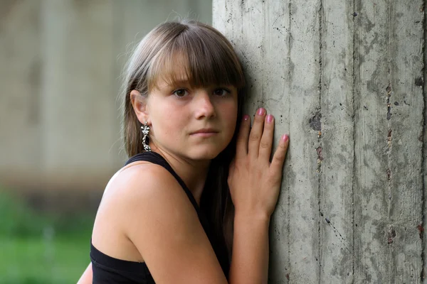 Jong meisje tegen muur. neerkijken — Stockfoto