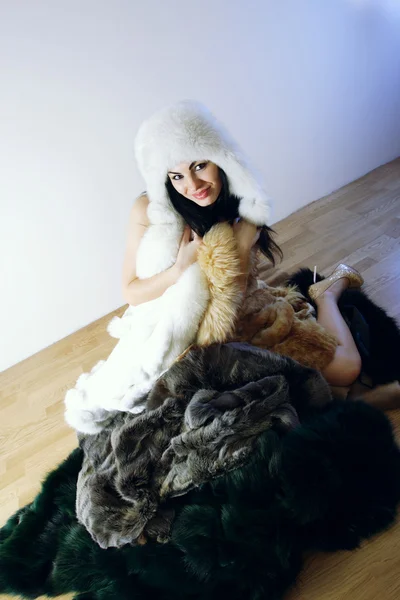 Chica joven con varios abrigos de piel natural — Foto de Stock